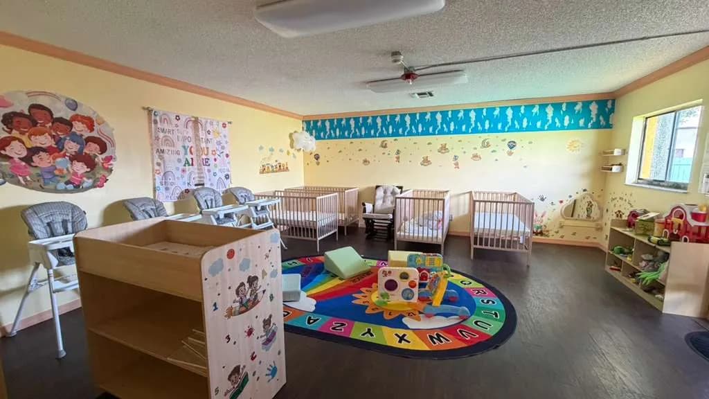 Infant room with cribs, high chairs and changing area at A Magic World Child Care Center in Palm Bay, FL