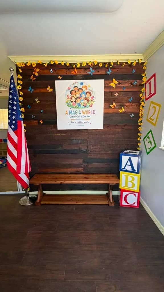 Welcome wall with A Magic World Child Care Center logo, American flag and wooden bench in Palm Bay, FL