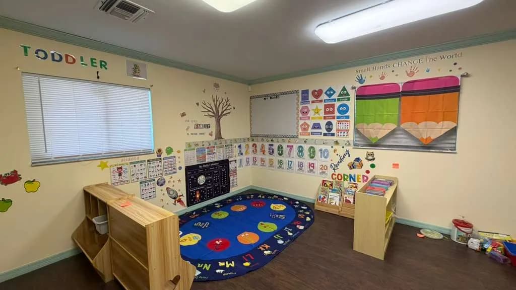 Cozy classroom reading corner with books and learning posters at A Magic World Child Care Center